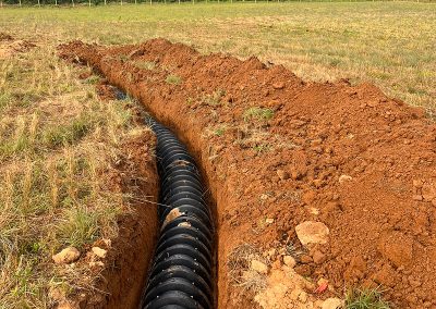 Excavator digging a septic tank hole during system installation